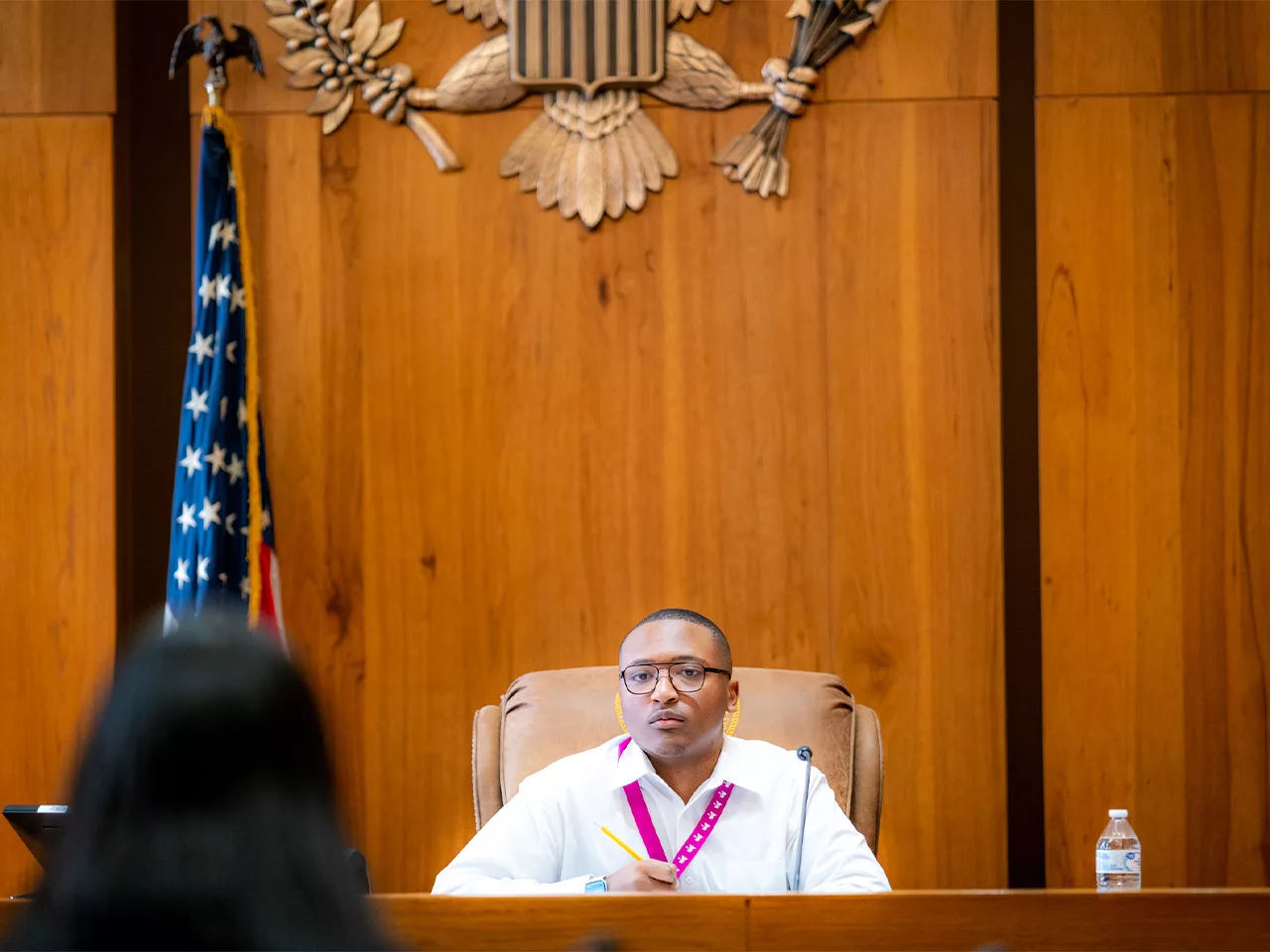 A teen sits in the judge's bench of a federal courthouse weighing the merits of a case.