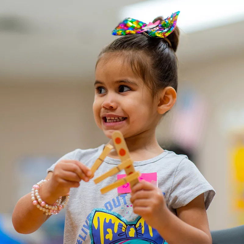 a child makes an art project using popsicle sticks