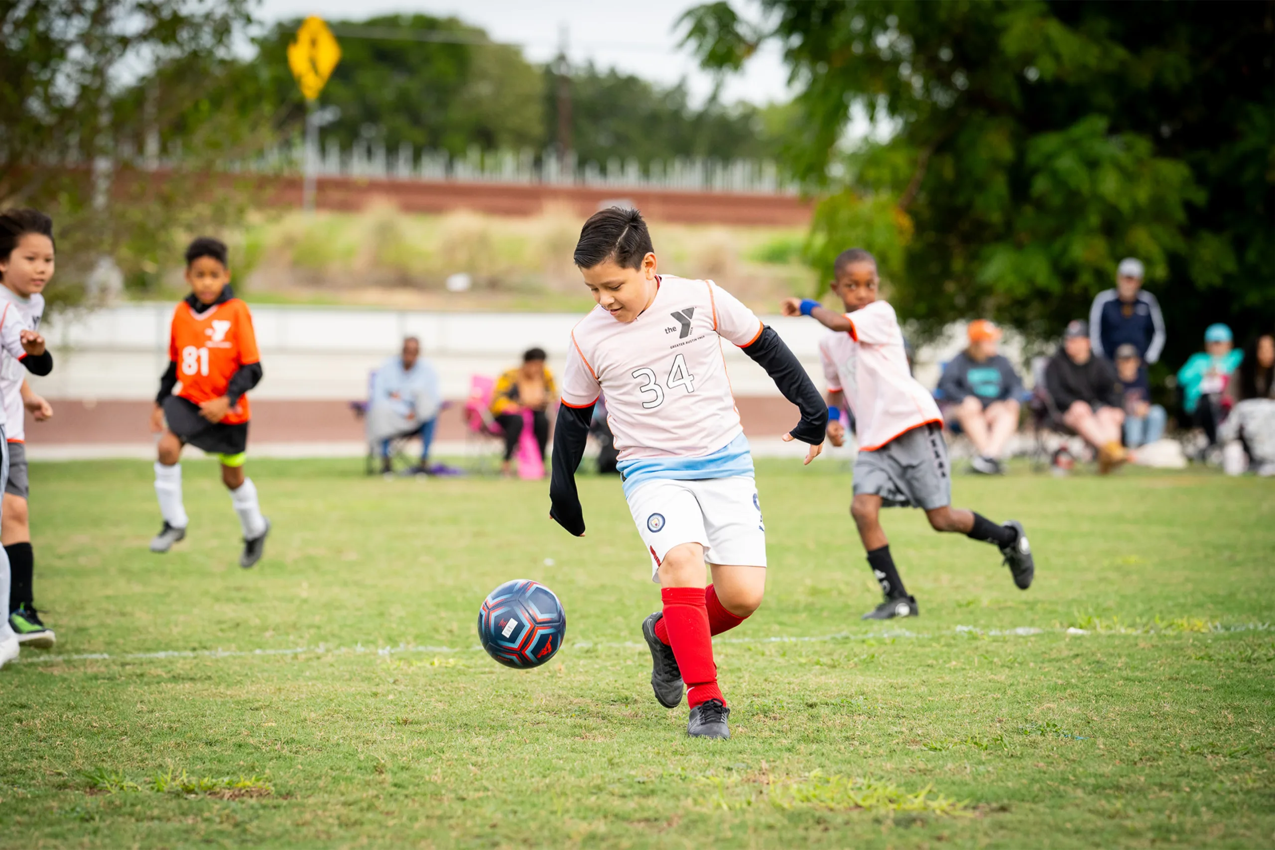 Children play a game of soccer outdoors.