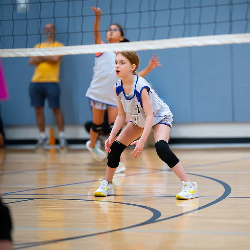 A teen plays a game of volleyball.