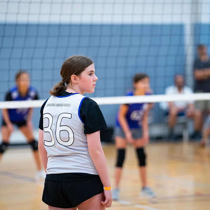 A teen plays a game of volleyball.