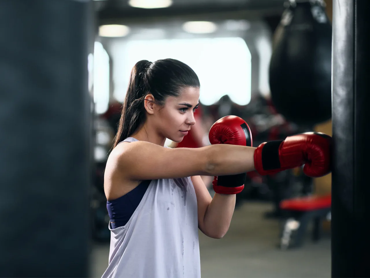 A young woman extends her arms in a boxing pose.