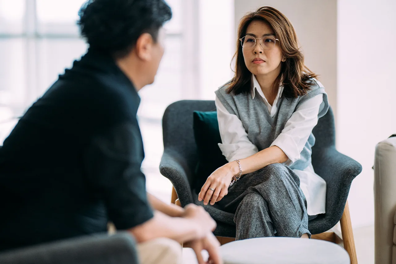 Two people face one another in deep conversation.