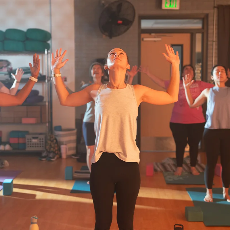 A group of adults participate in a group yoga class