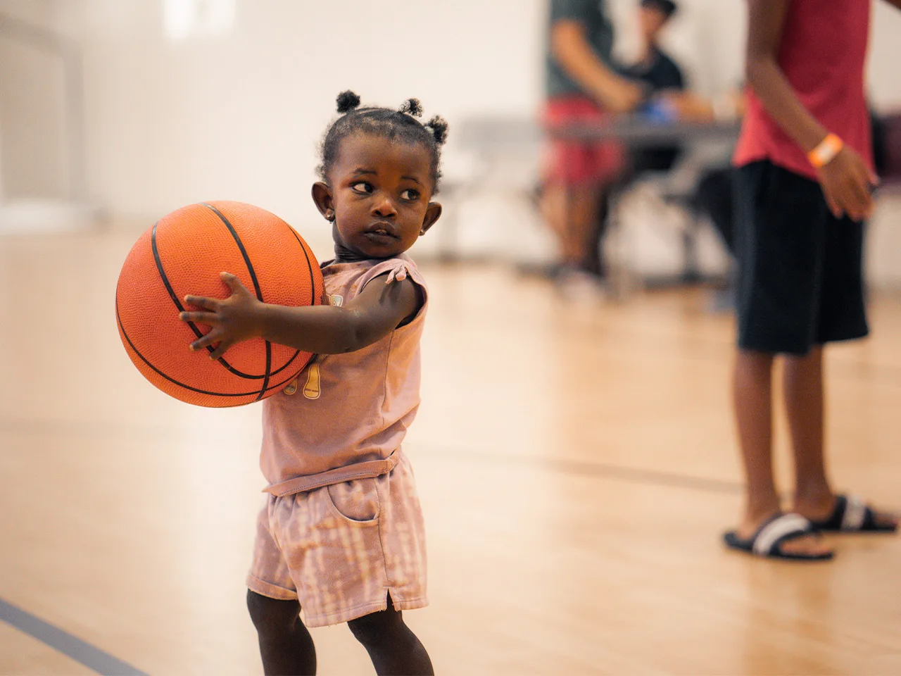 A toddler holds a basketball