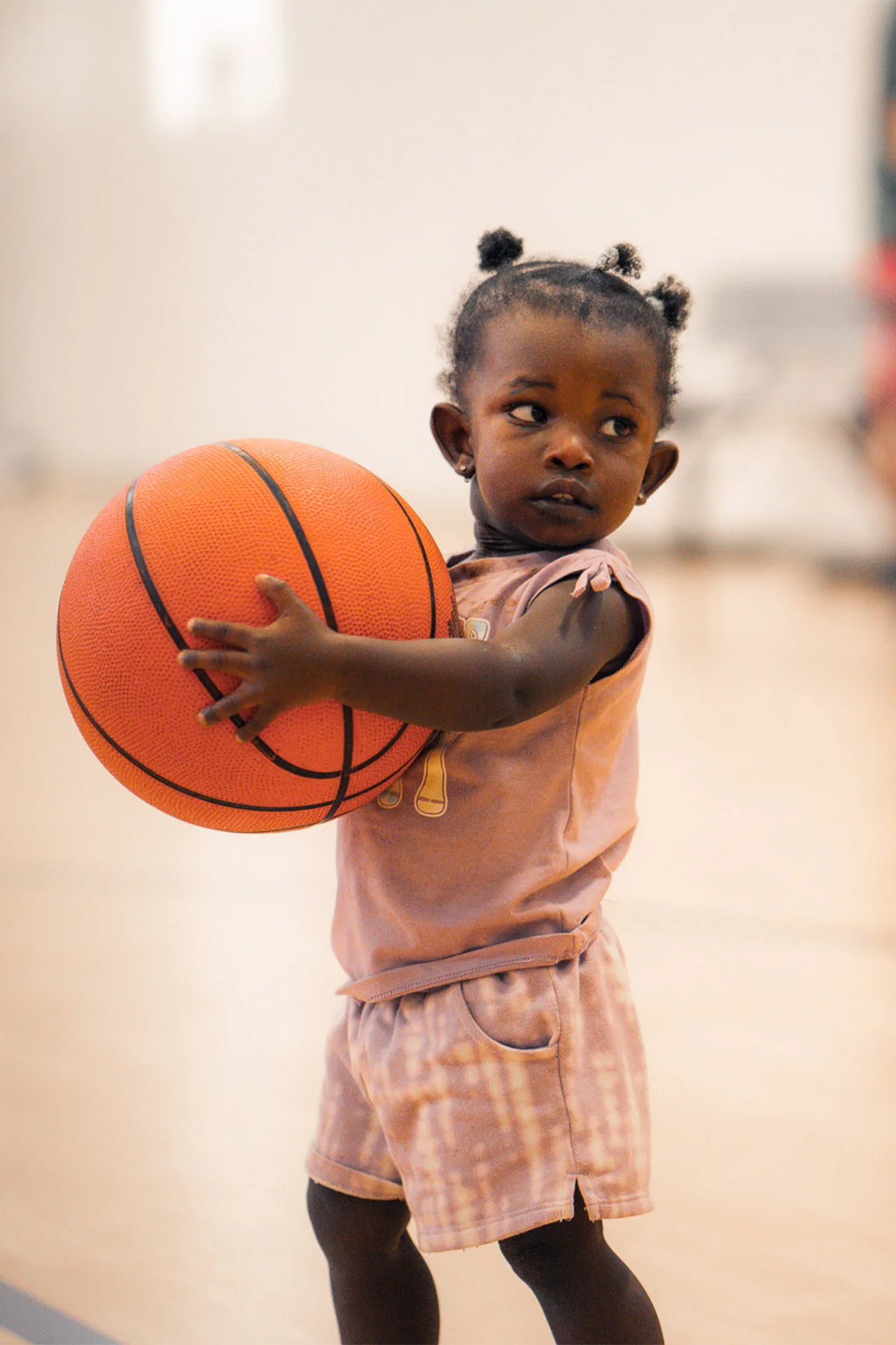 A toddler holds a basketball