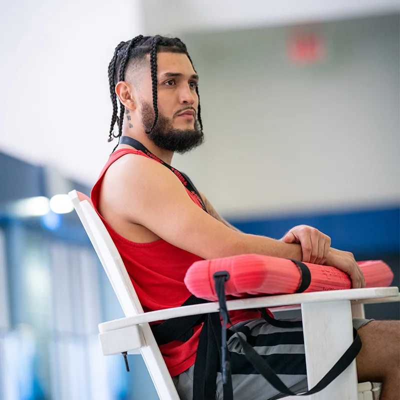 A lifeguard surveys a pool, watching it closely.