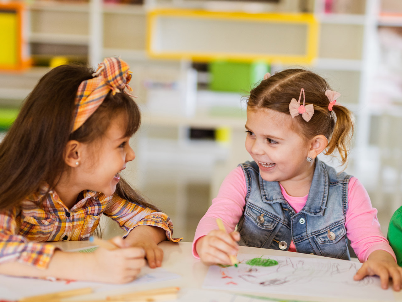 little girls color together and laugh