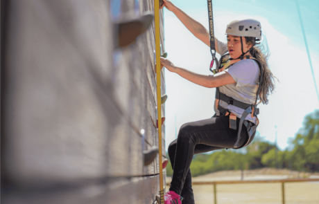 A girl at Camp Moody focuses on climbing the rock wall.